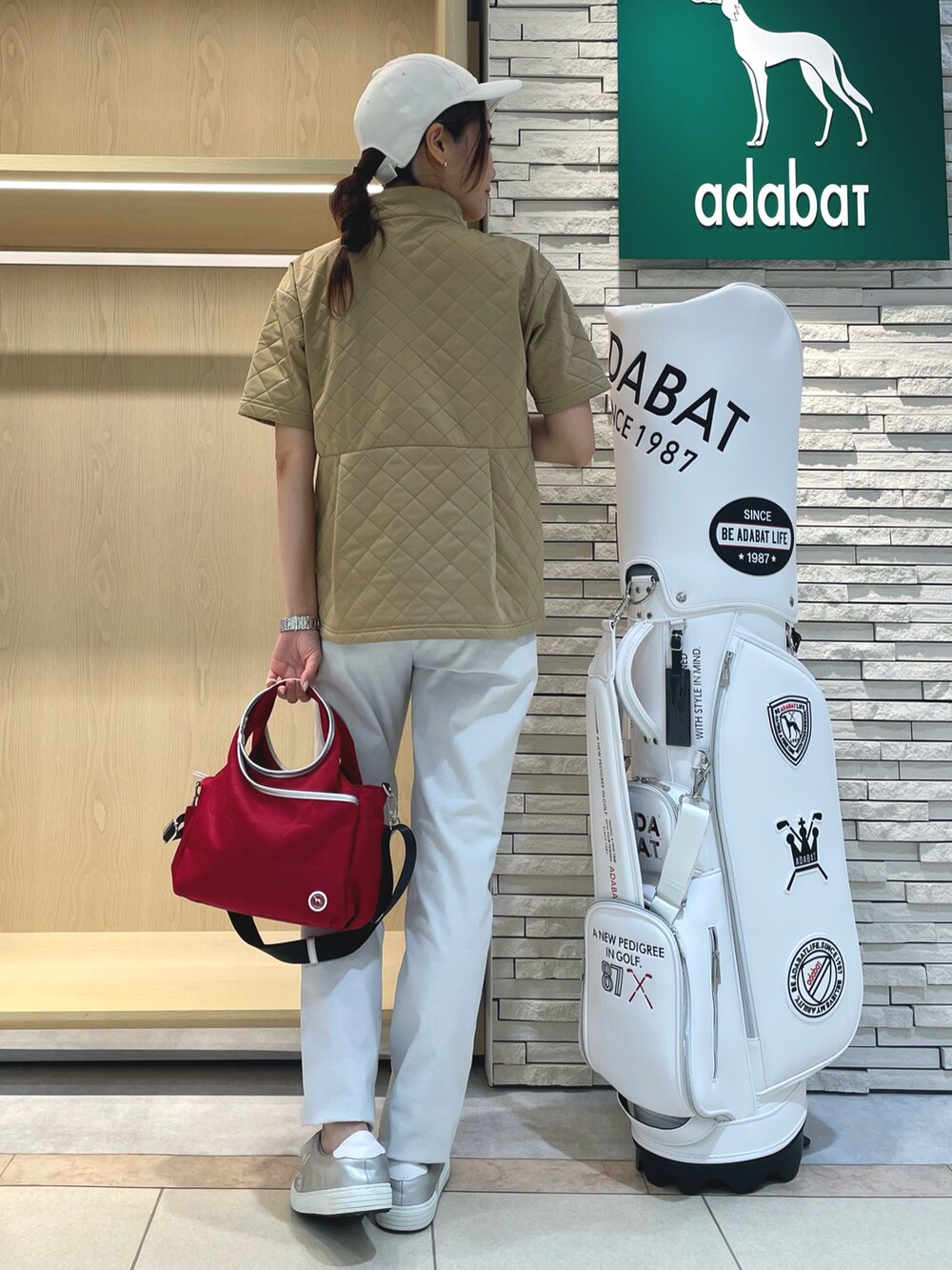 イエロー系のTシャツ/カットソー、グレー系のその他パンツ、レッド系のハンドバッグを着用したレディースの秋コーディネートの3枚目の写真