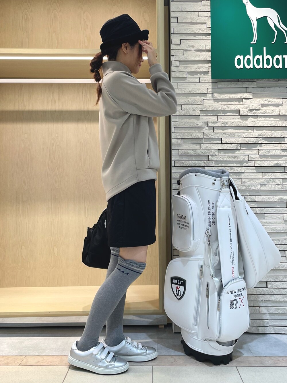 ベージュ系のTシャツ/カットソー、ブラック系のスカート、ブラック系のハンドバッグを着用したレディースの秋コーディネートの2枚目の写真