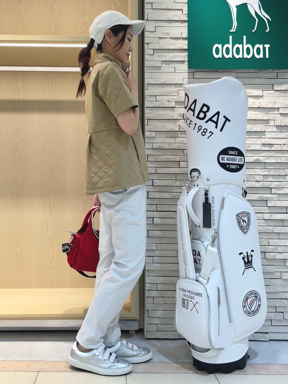 イエロー系のTシャツ/カットソー、グレー系のその他パンツ、レッド系のハンドバッグを着用したレディースの秋コーディネートの2枚目の写真