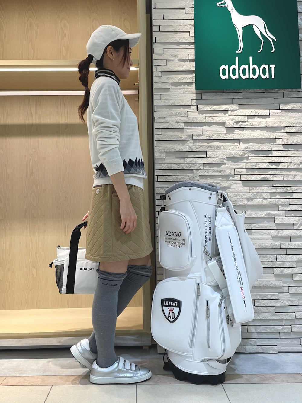 ホワイト系のニット/セーター、イエロー系のスカート、ホワイト系のトートバッグを着用したレディースの冬コーディネートの2枚目の写真