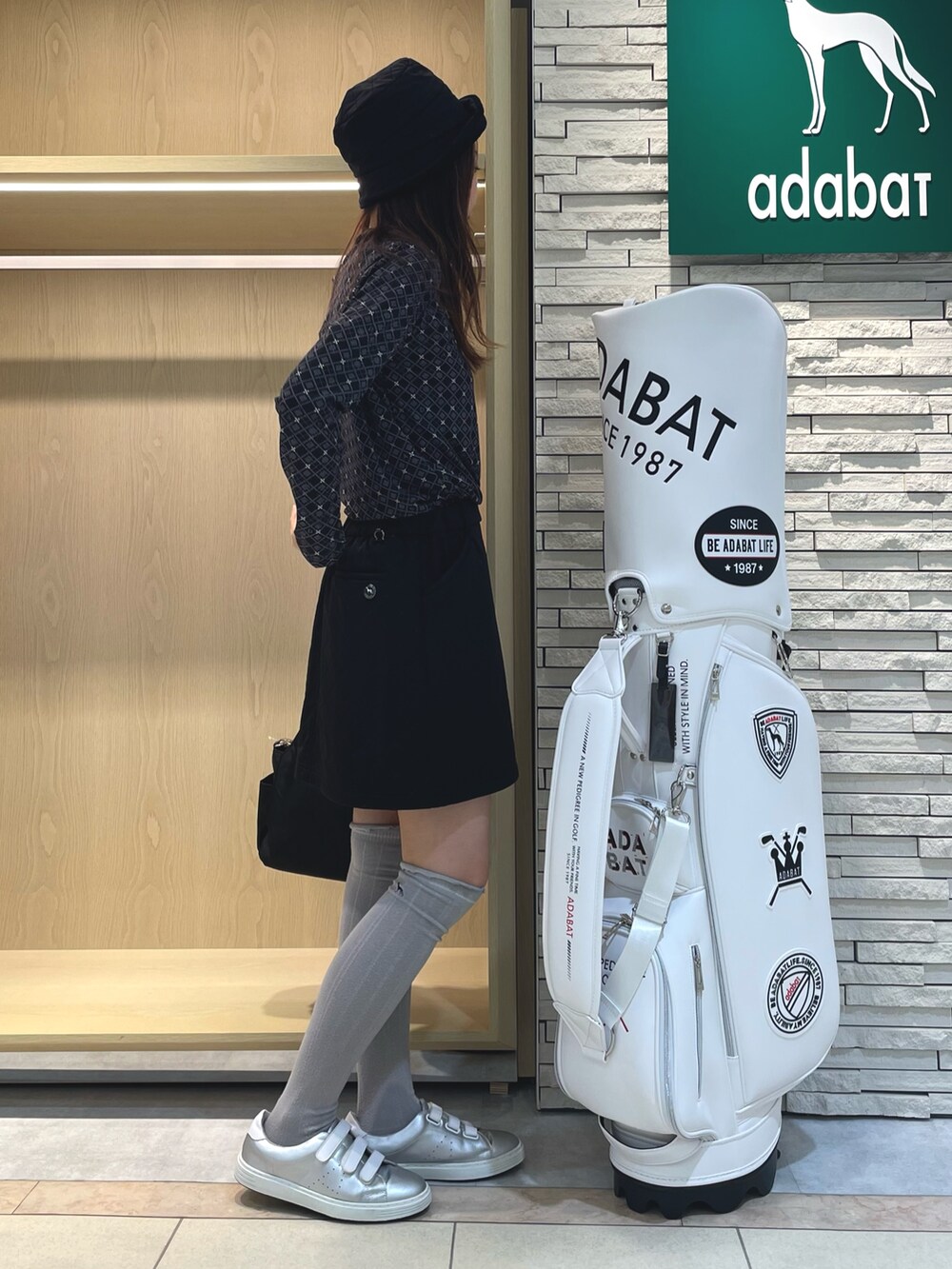 ブラック系のスカート、ブラック系のTシャツ/カットソー、ブラック系のハンドバッグを着用したレディースの秋コーディネートの2枚目の写真