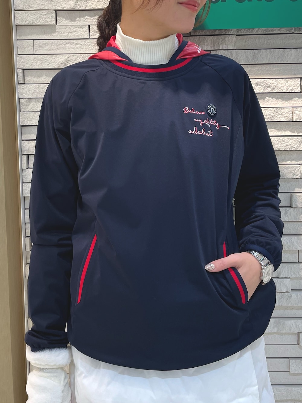 ブルー系のブルゾン、ホワイト系のスカート、ホワイト系のハンドバッグを着用したレディースの冬コーディネートの4枚目の写真