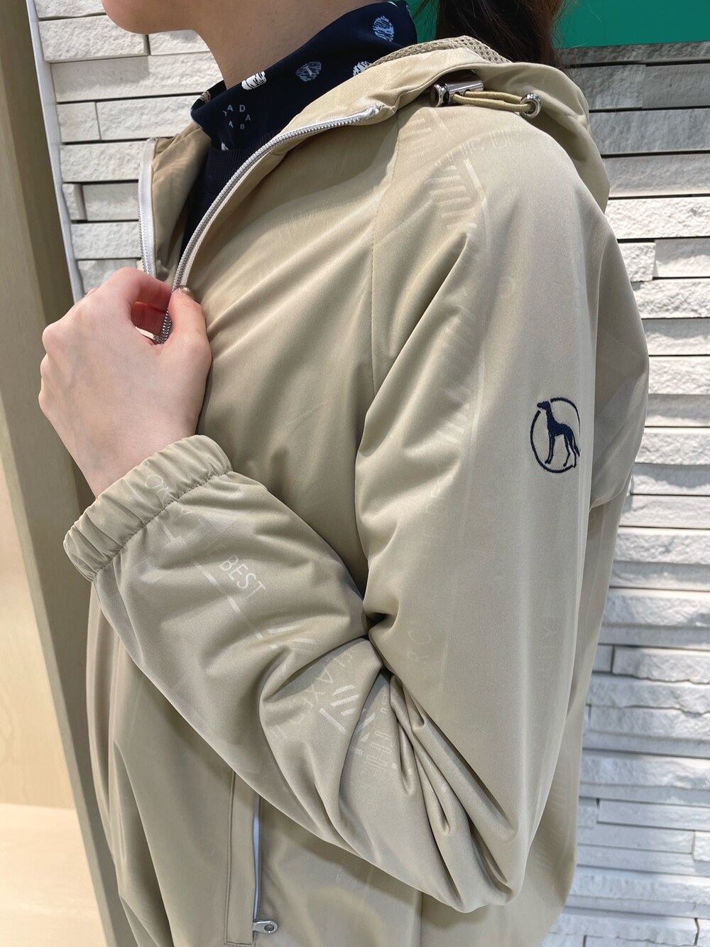 ブルー系のスカート、ベージュ系のブルゾン、ブルー系のニット/セーターを着用したレディースの春コーディネートの6枚目の写真