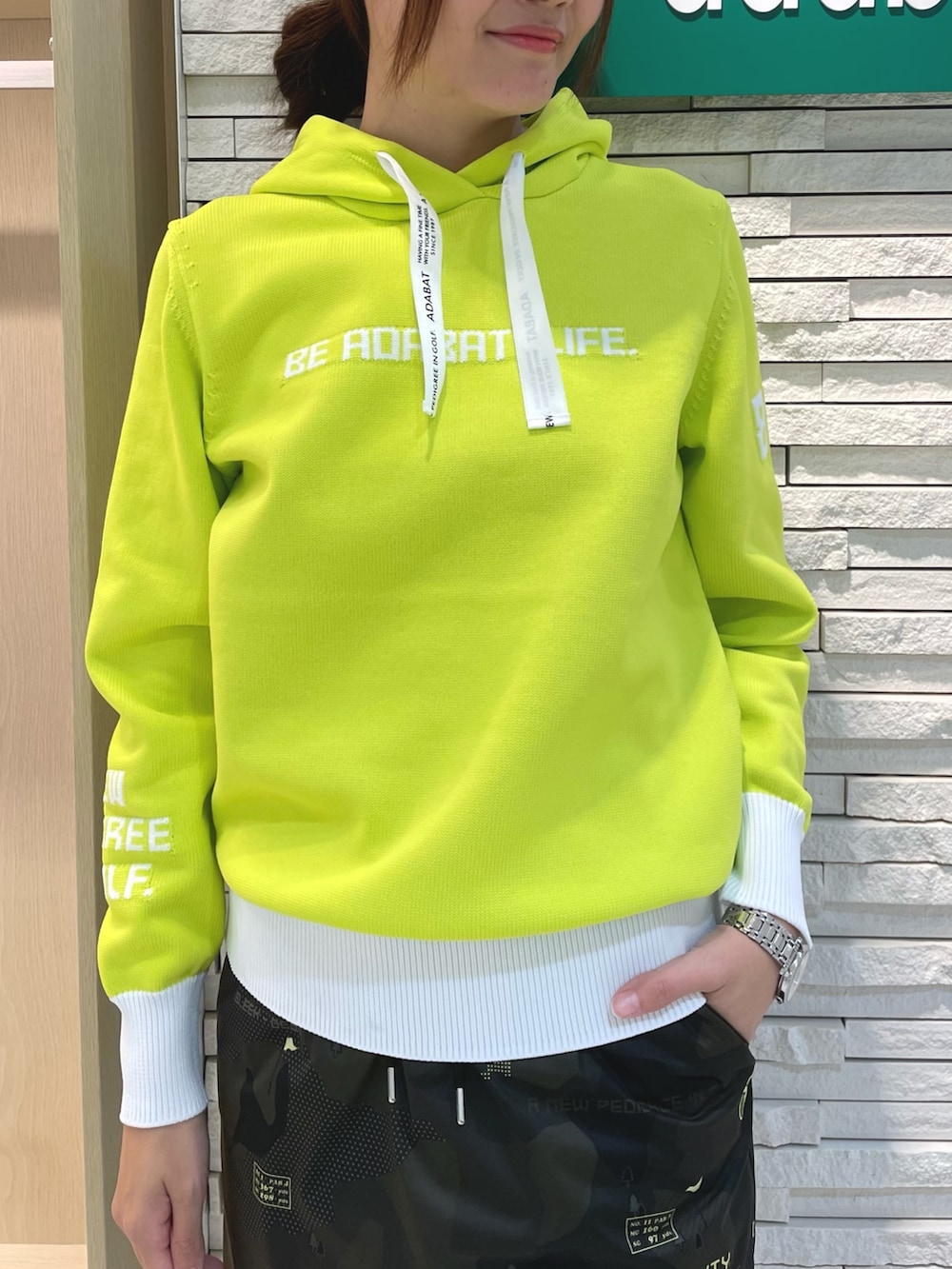 グリーン系のスカート、イエロー系のニット/セーター、ホワイト系のハンドバッグを着用したレディースの秋コーディネートの4枚目の写真