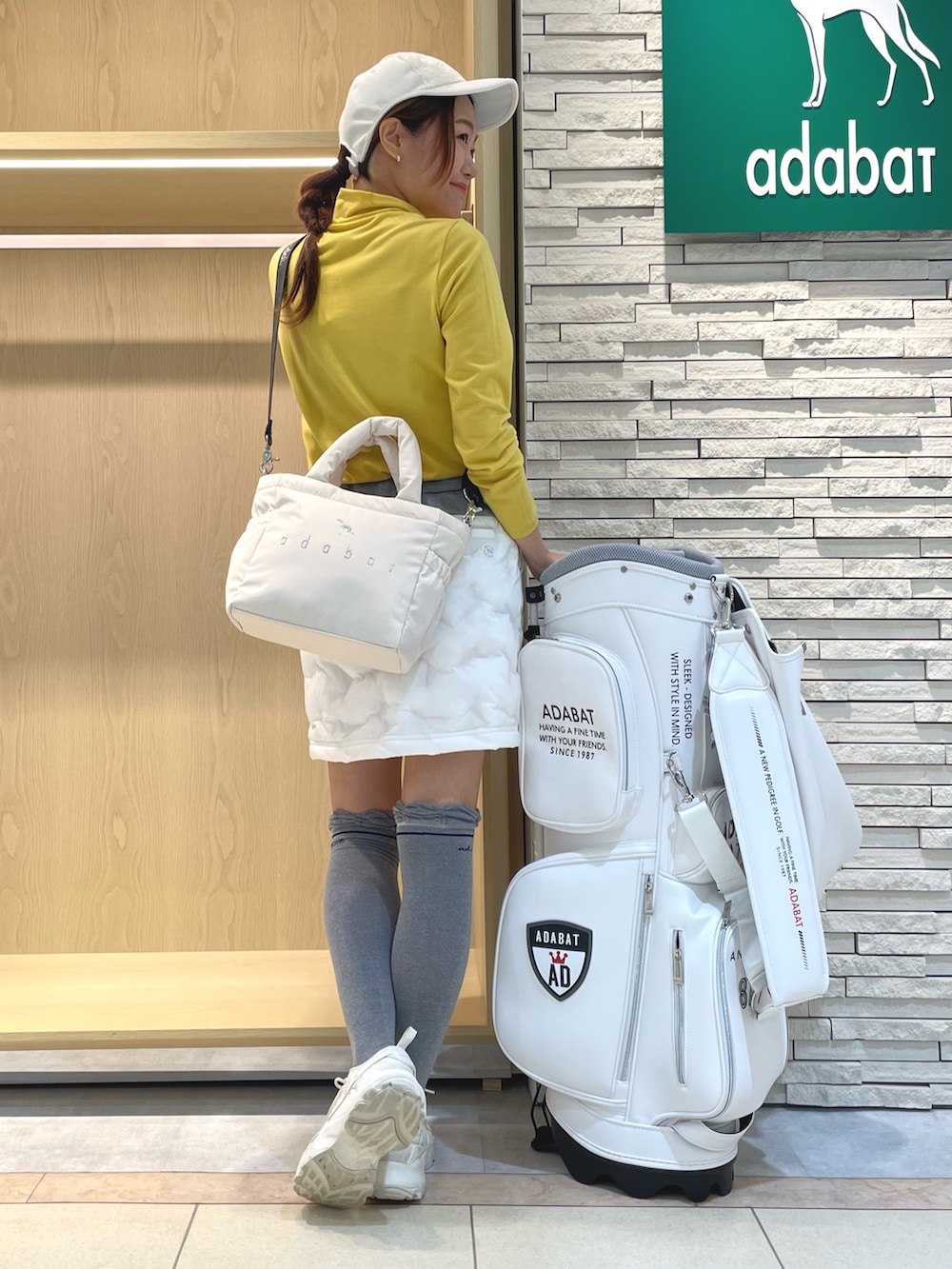 ホワイト系のスカート、イエロー系のTシャツ/カットソー、ホワイト系のハンドバッグを着用したレディースの冬コーディネートの3枚目の写真