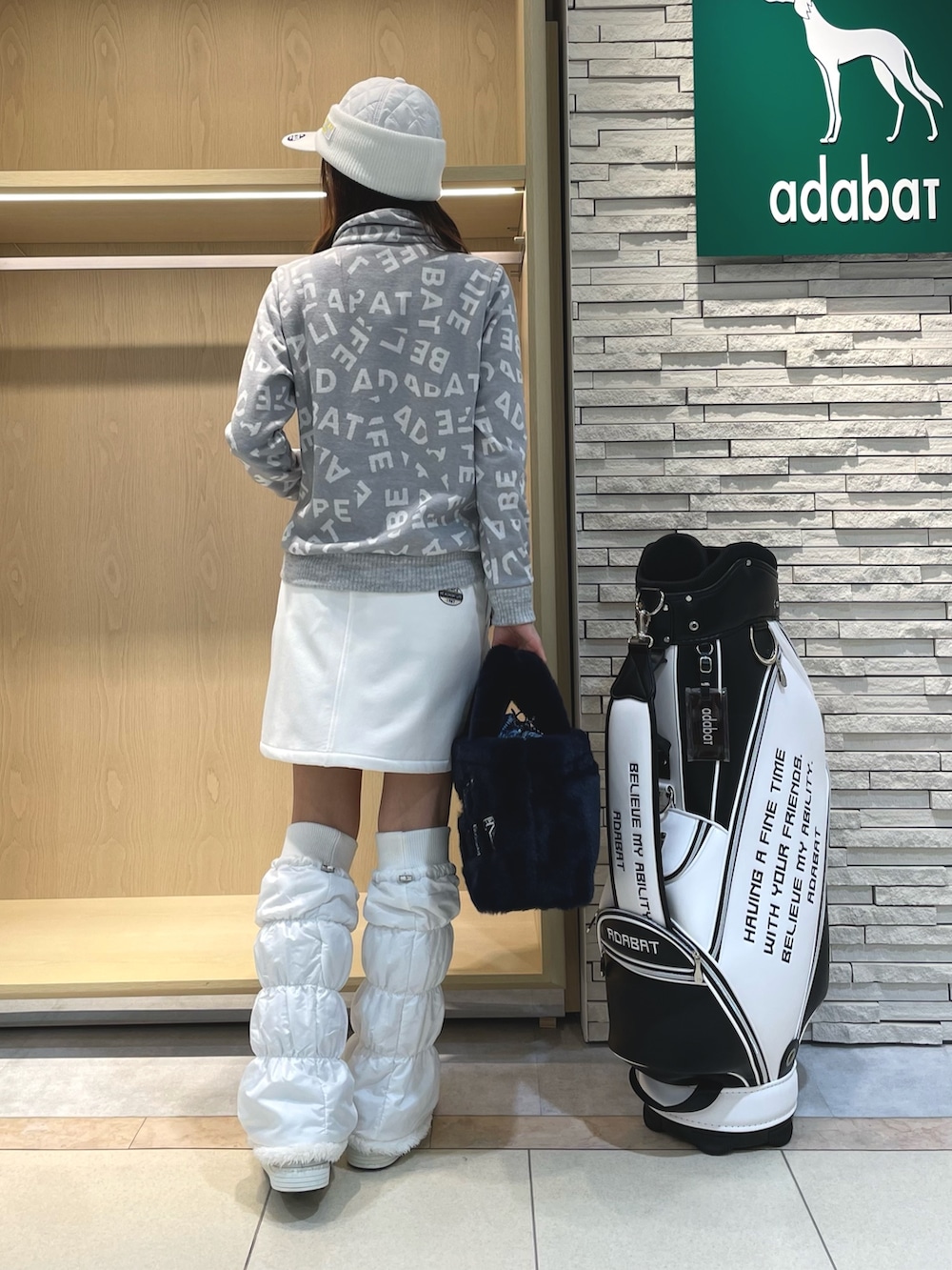 ホワイト系のスカート、グレー系のTシャツ/カットソー、ブルー系のハンドバッグを着用したレディースの冬コーディネートの3枚目の写真