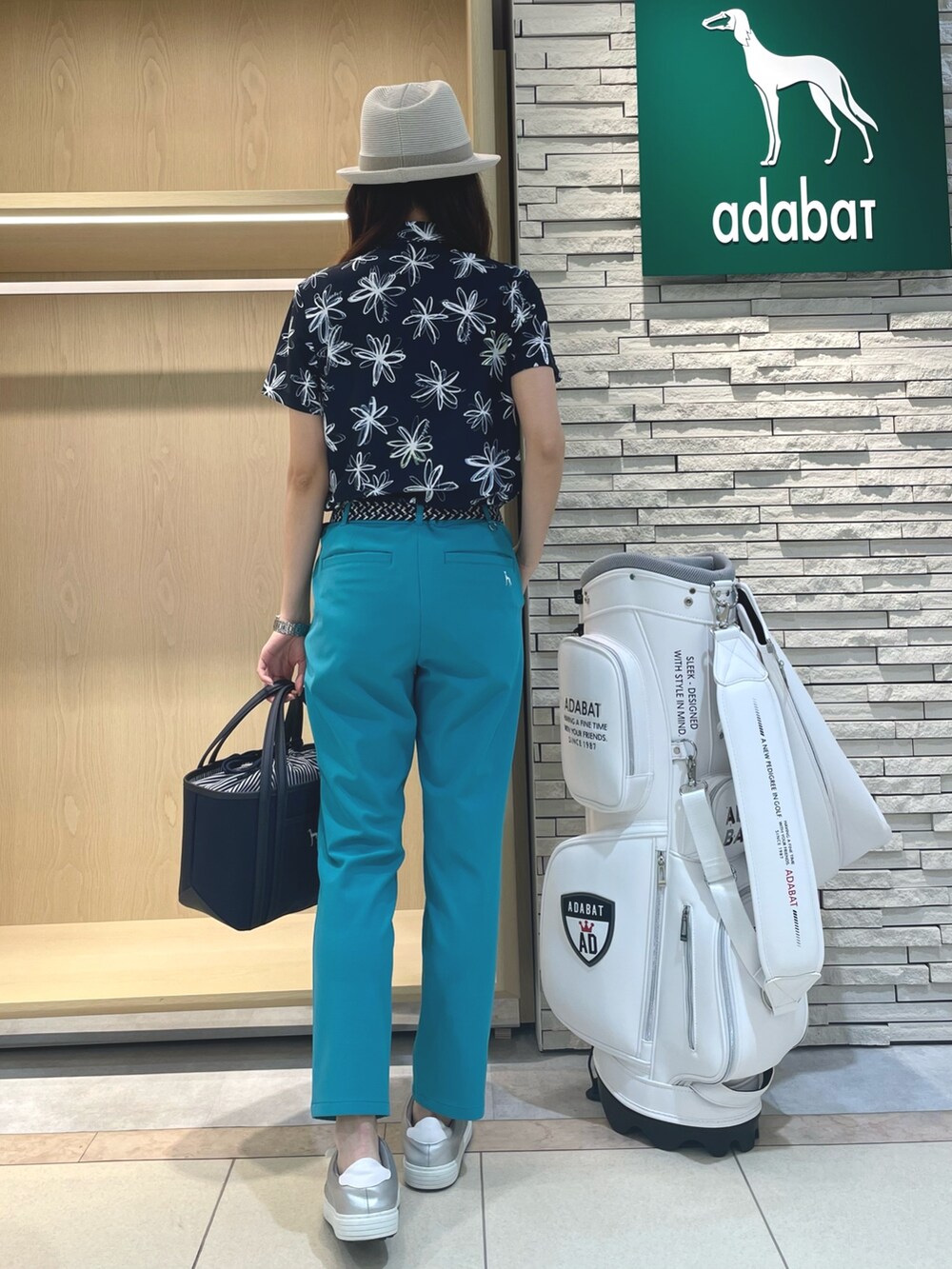 グリーン系のその他パンツ、ブルー系のポロシャツ、ブルー系のトートバッグを着用したレディースの春コーディネートの3枚目の写真