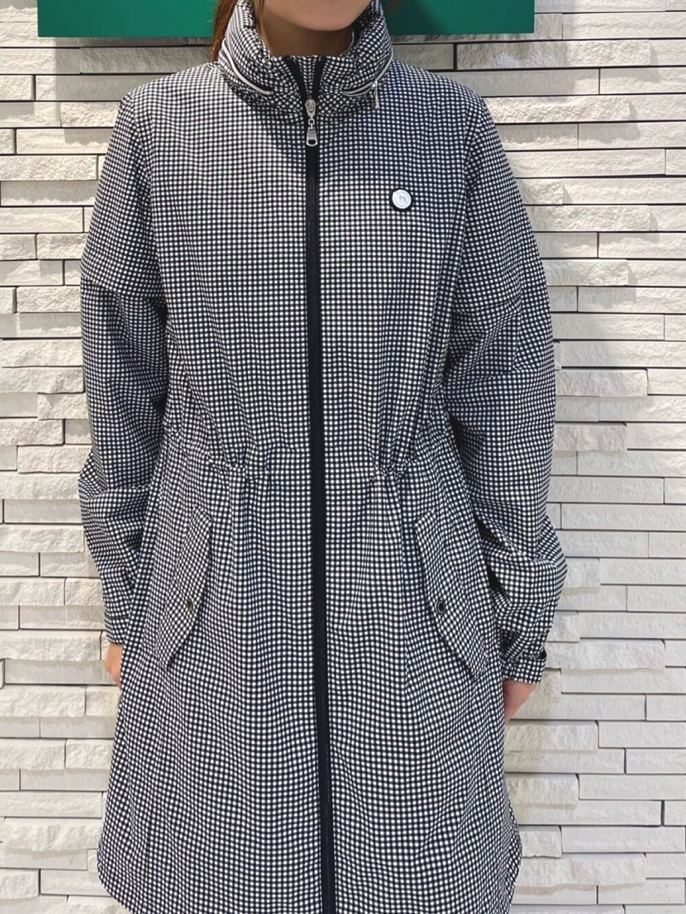 ブルー系のトートバッグ、ホワイト系のブルゾン、ホワイト系のサンバイザーを着用したレディースの夏コーディネートの3枚目の写真