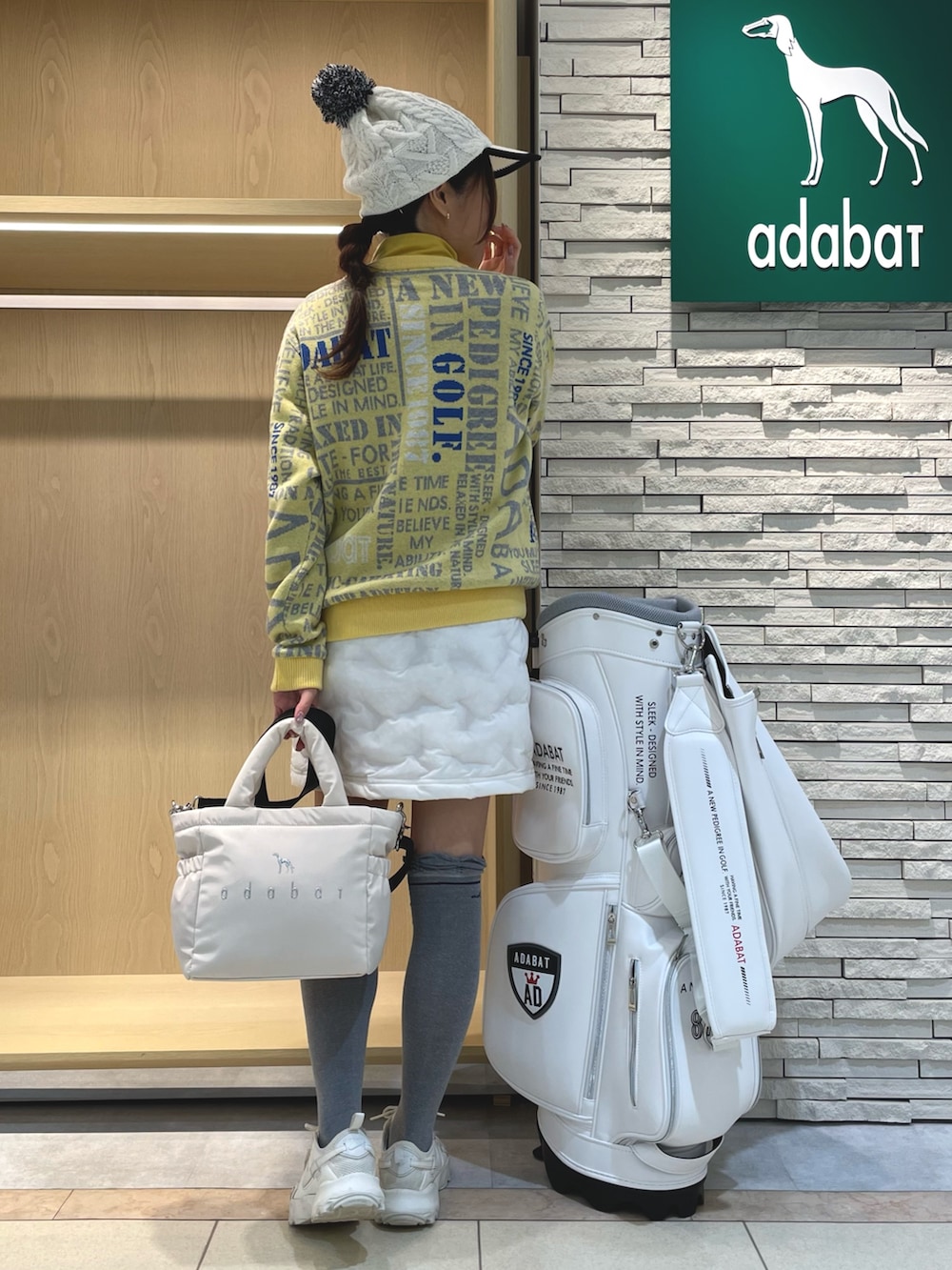 ホワイト系のスカート、イエロー系のニット/セーター、ホワイト系のハンドバッグを着用したレディースの冬コーディネートの3枚目の写真