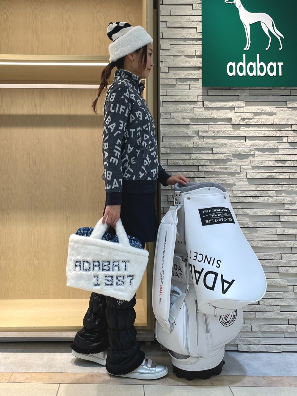 ブルー系のTシャツ/カットソー、ブルー系のスカート、ホワイト系のハンドバッグを着用したレディースの冬コーディネートの2枚目の写真