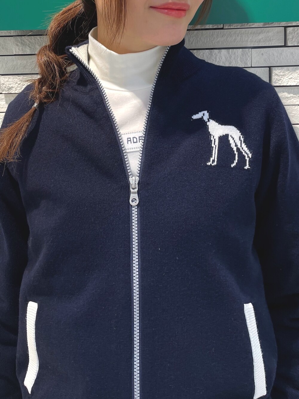 ブルー系のスカート、ホワイト系のハンドバッグ、ブルー系のニット/セーターを着用したレディースの冬コーディネートの4枚目の写真