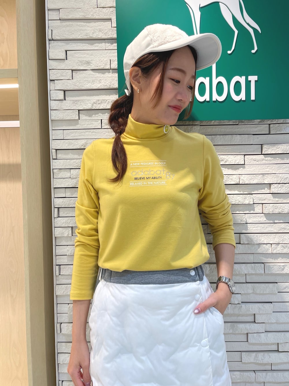 ホワイト系のスカート、イエロー系のTシャツ/カットソー、ホワイト系のハンドバッグを着用したレディースの冬コーディネートの4枚目の写真