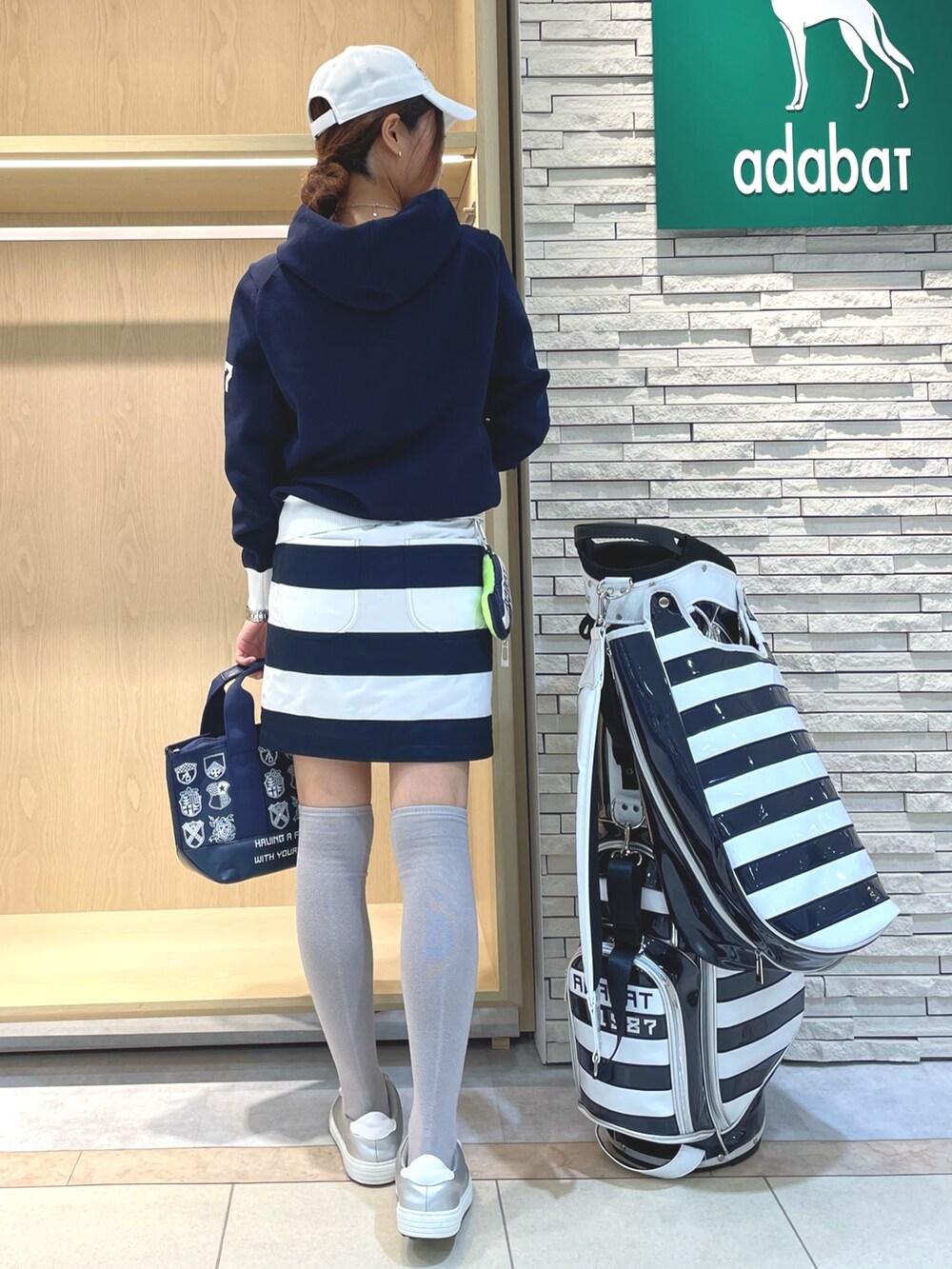 ホワイト系のスカート、ブルー系のニット/セーター、ブルー系のトートバッグを着用したレディースの秋コーディネートの3枚目の写真