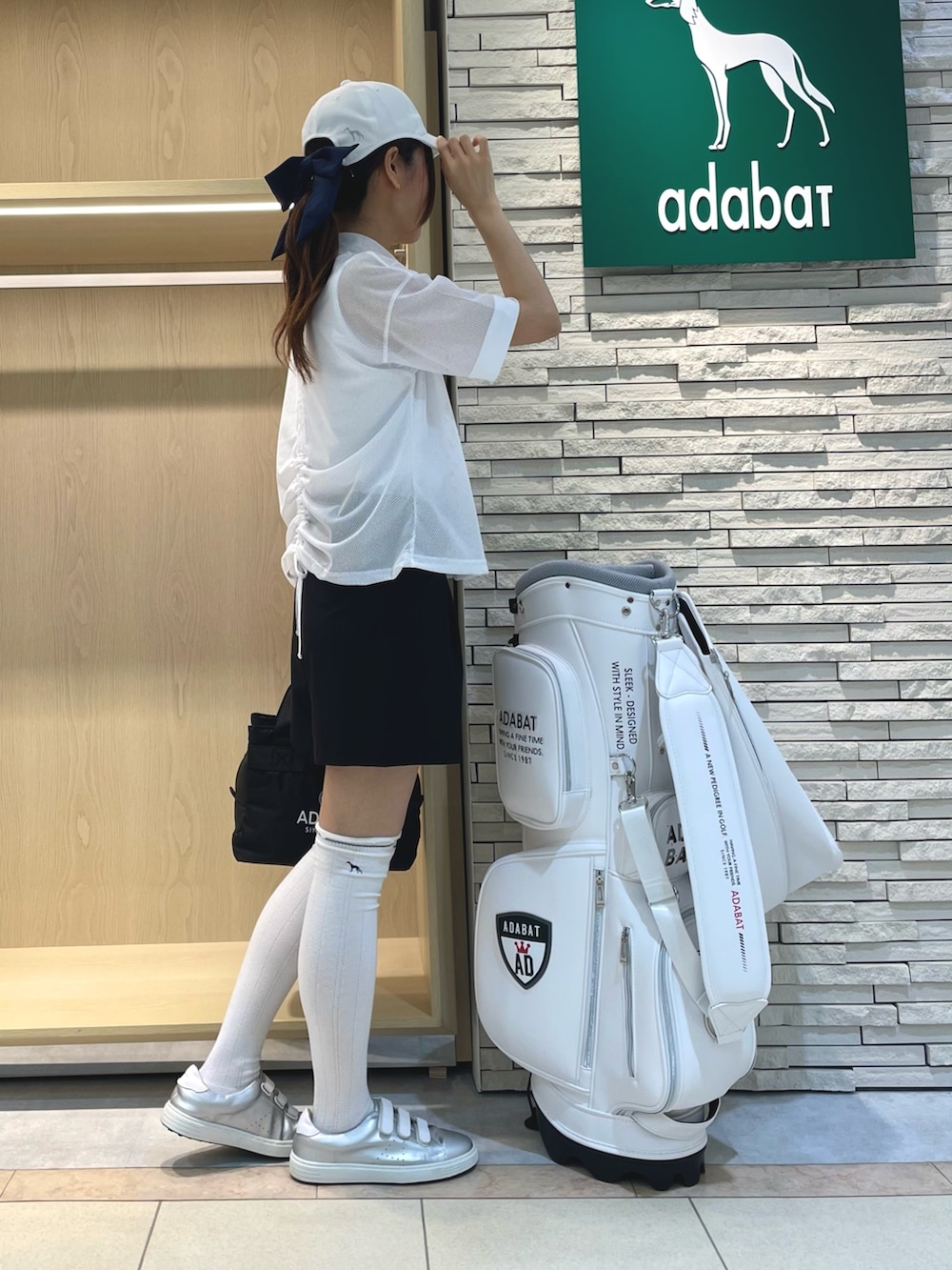 ホワイト系のTシャツ/カットソー、ブラック系のその他パンツ、ホワイト系のキャップを着用したレディースの春コーディネートの2枚目の写真