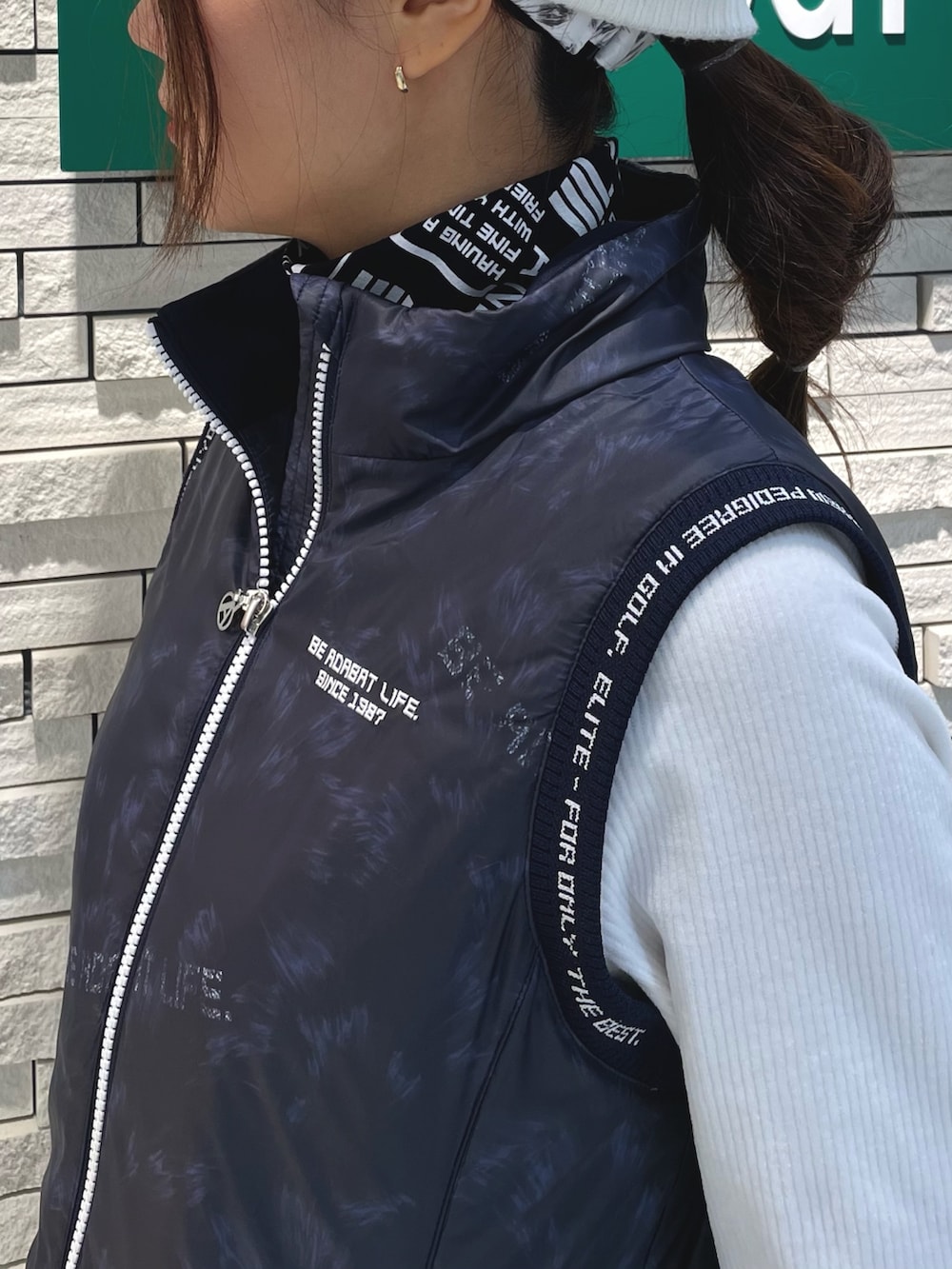 ブルー系のワンピース、ホワイト系のハンドバッグ、ホワイト系のTシャツ/カットソーを着用したレディースの冬コーディネートの4枚目の写真