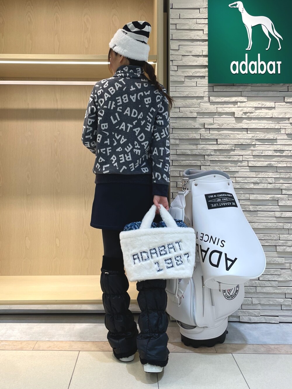 ブルー系のTシャツ/カットソー、ブルー系のスカート、ホワイト系のハンドバッグを着用したレディースの冬コーディネートの3枚目の写真