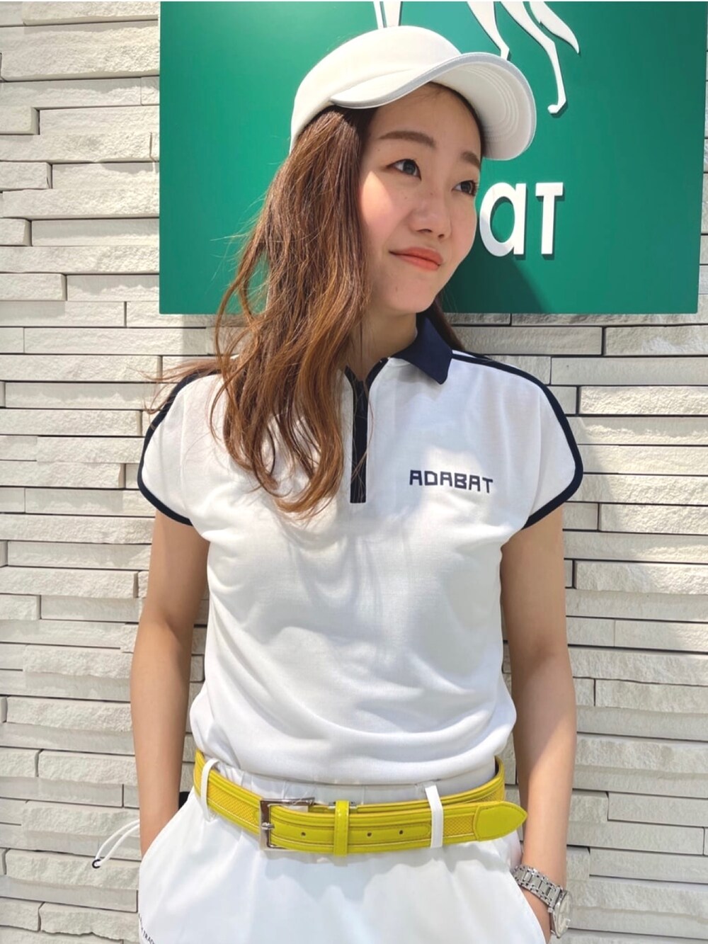 ホワイト系のスカート、ホワイト系のポロシャツ、ホワイト系のスニーカーを着用したレディースの夏コーディネートの3枚目の写真