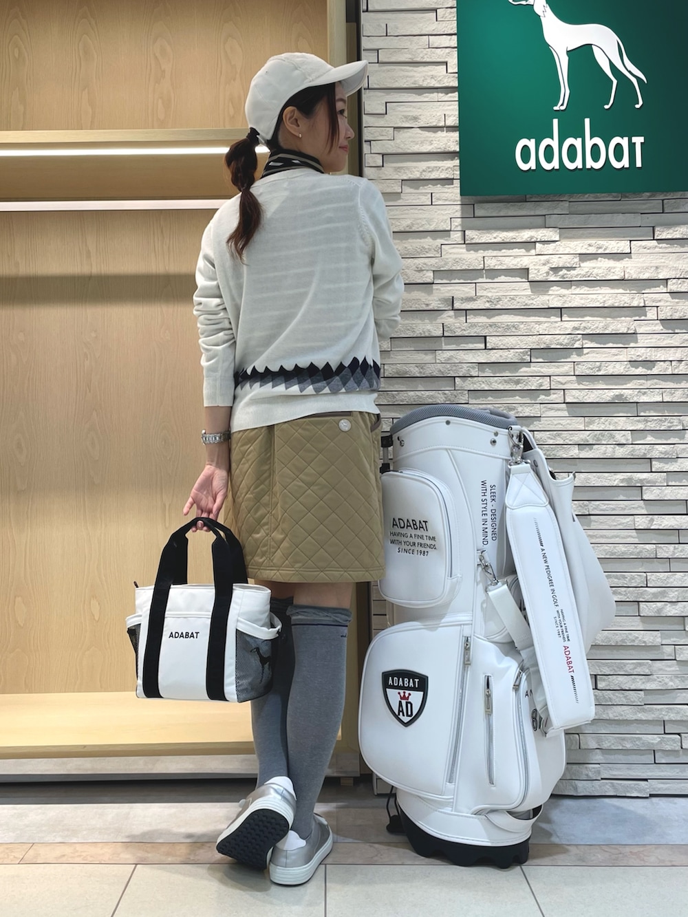 ホワイト系のニット/セーター、イエロー系のスカート、ホワイト系のトートバッグを着用したレディースの冬コーディネートの3枚目の写真