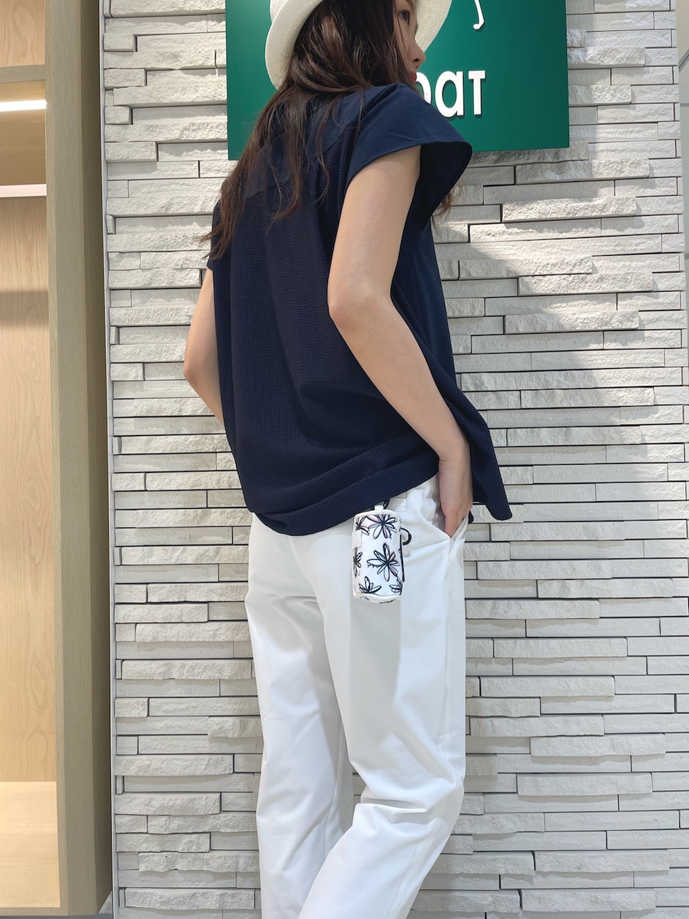 ブルー系のポロシャツ、ホワイト系のその他パンツ、ホワイト系のハンドバッグを着用したレディースの春コーディネートの4枚目の写真