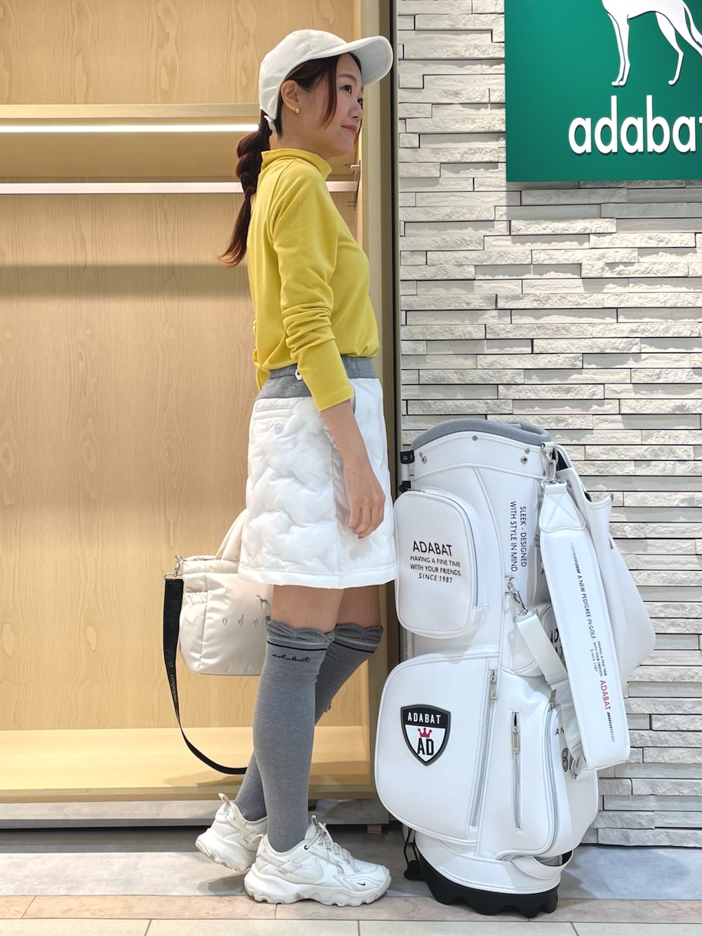 ホワイト系のスカート、イエロー系のTシャツ/カットソー、ホワイト系のハンドバッグを着用したレディースの冬コーディネートの2枚目の写真