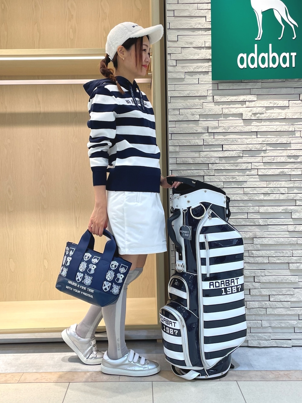 ホワイト系のニット/セーター、グリーン系のスカート、ブルー系のトートバッグを着用したレディースの秋コーディネートの2枚目の写真