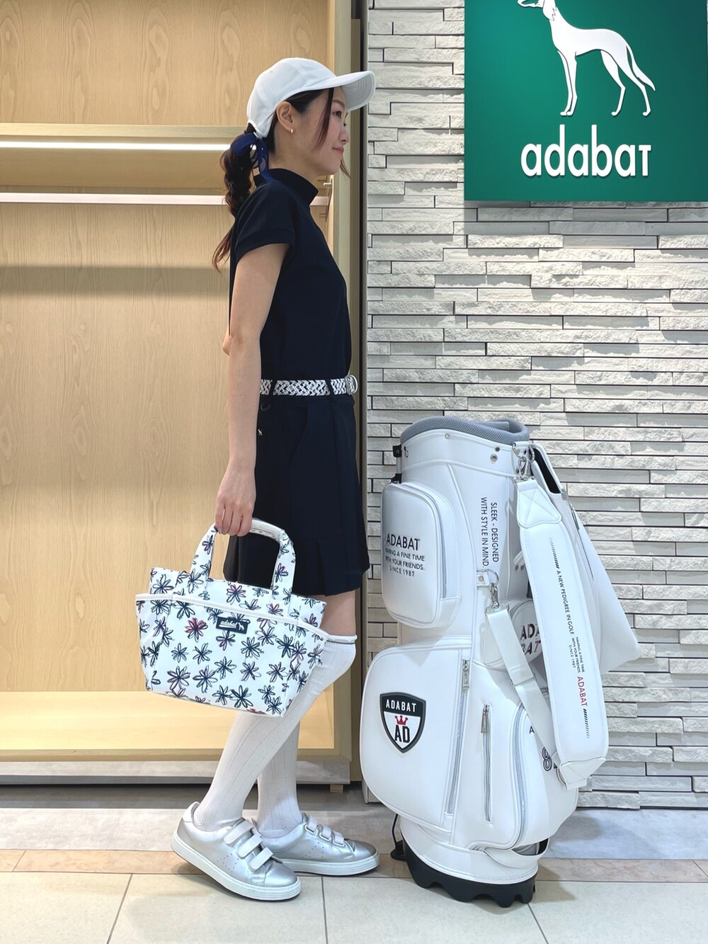 ブラック系のスカート、ブルー系のTシャツ/カットソー、ホワイト系のハンドバッグを着用したレディースの春コーディネートの2枚目の写真