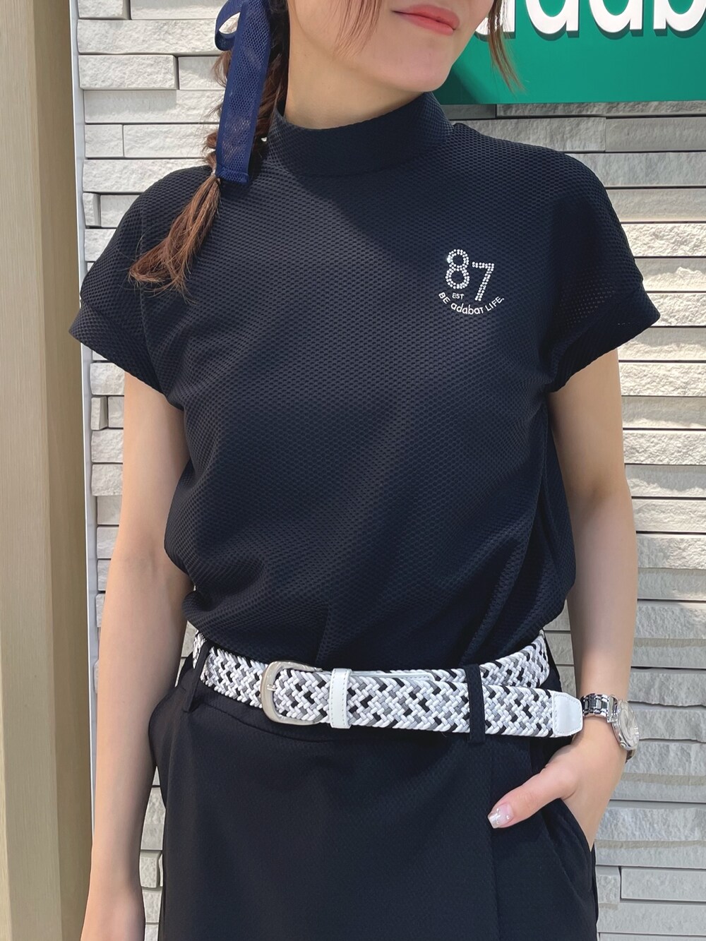 ブラック系のスカート、ブルー系のTシャツ/カットソー、ホワイト系のハンドバッグを着用したレディースの春コーディネートの4枚目の写真