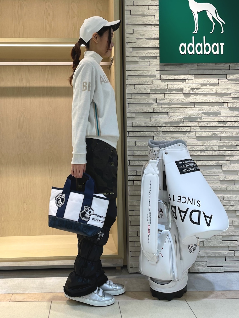 グリーン系のスカート、ホワイト系のニット/セーター、ホワイト系のTシャツ/カットソーを着用したレディースの冬コーディネートの3枚目の写真