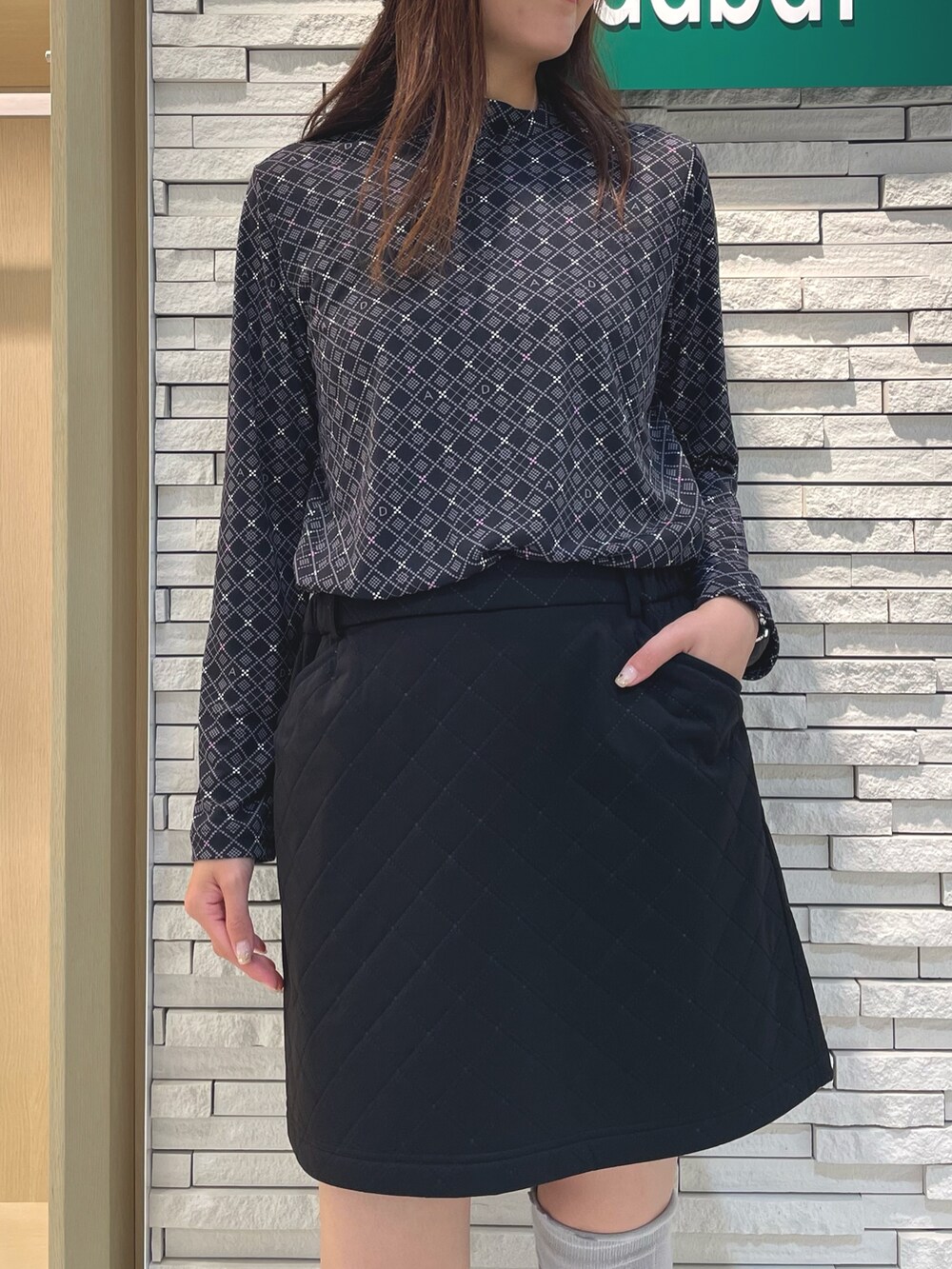 ブラック系のスカート、ブラック系のTシャツ/カットソー、ブラック系のハンドバッグを着用したレディースの秋コーディネートの4枚目の写真