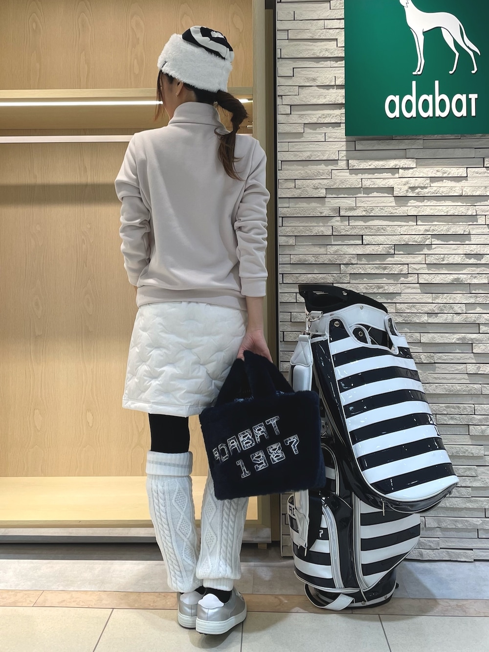 ホワイト系のスカート、ベージュ系のTシャツ/カットソー、ホワイト系のニットキャップ/ビーニーを着用したレディースの冬コーディネートの2枚目の写真