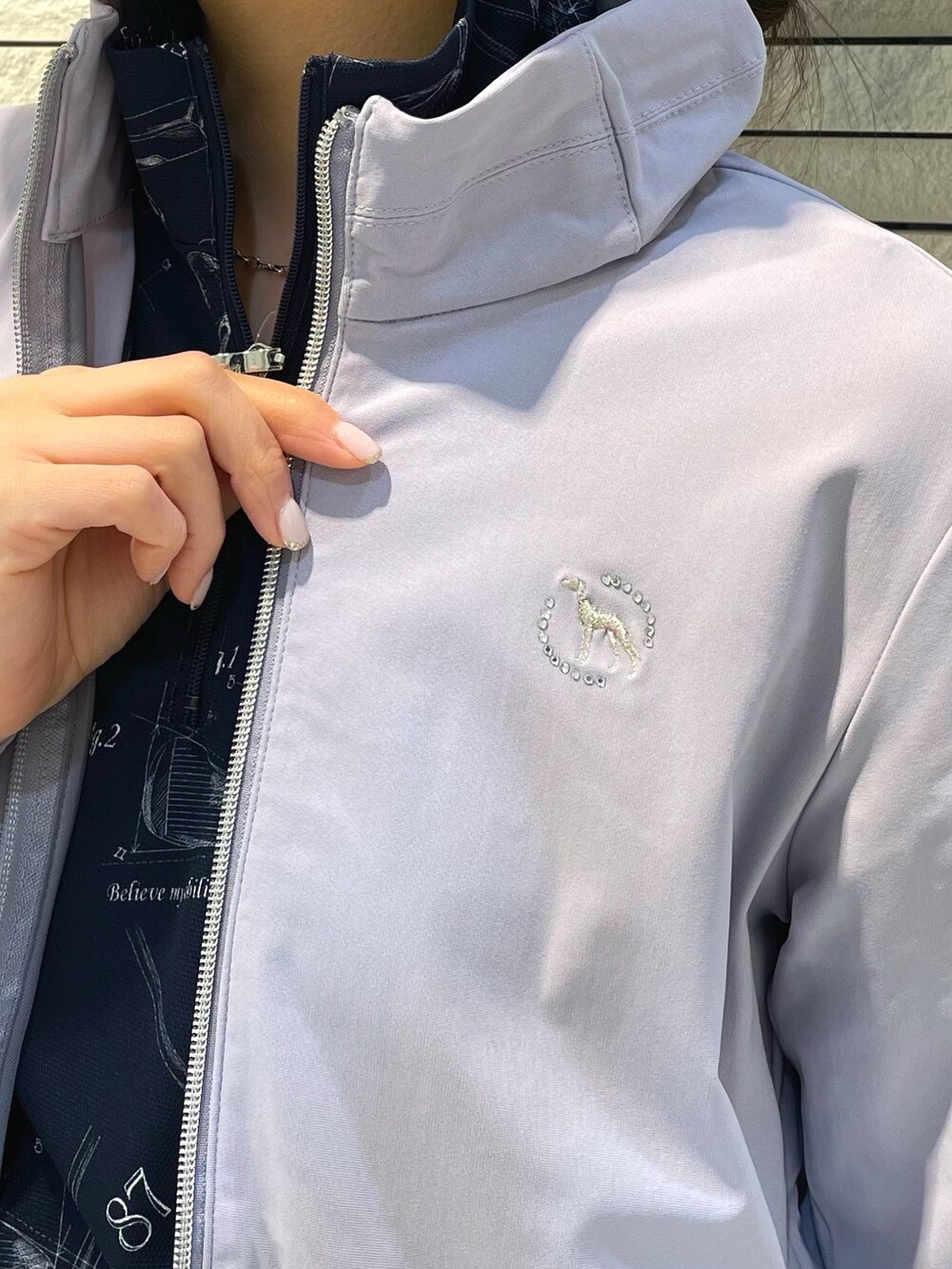 グレー系のブルゾン、ブルー系のTシャツ/カットソー、ホワイト系のトートバッグを着用したレディースの春コーディネートの4枚目の写真