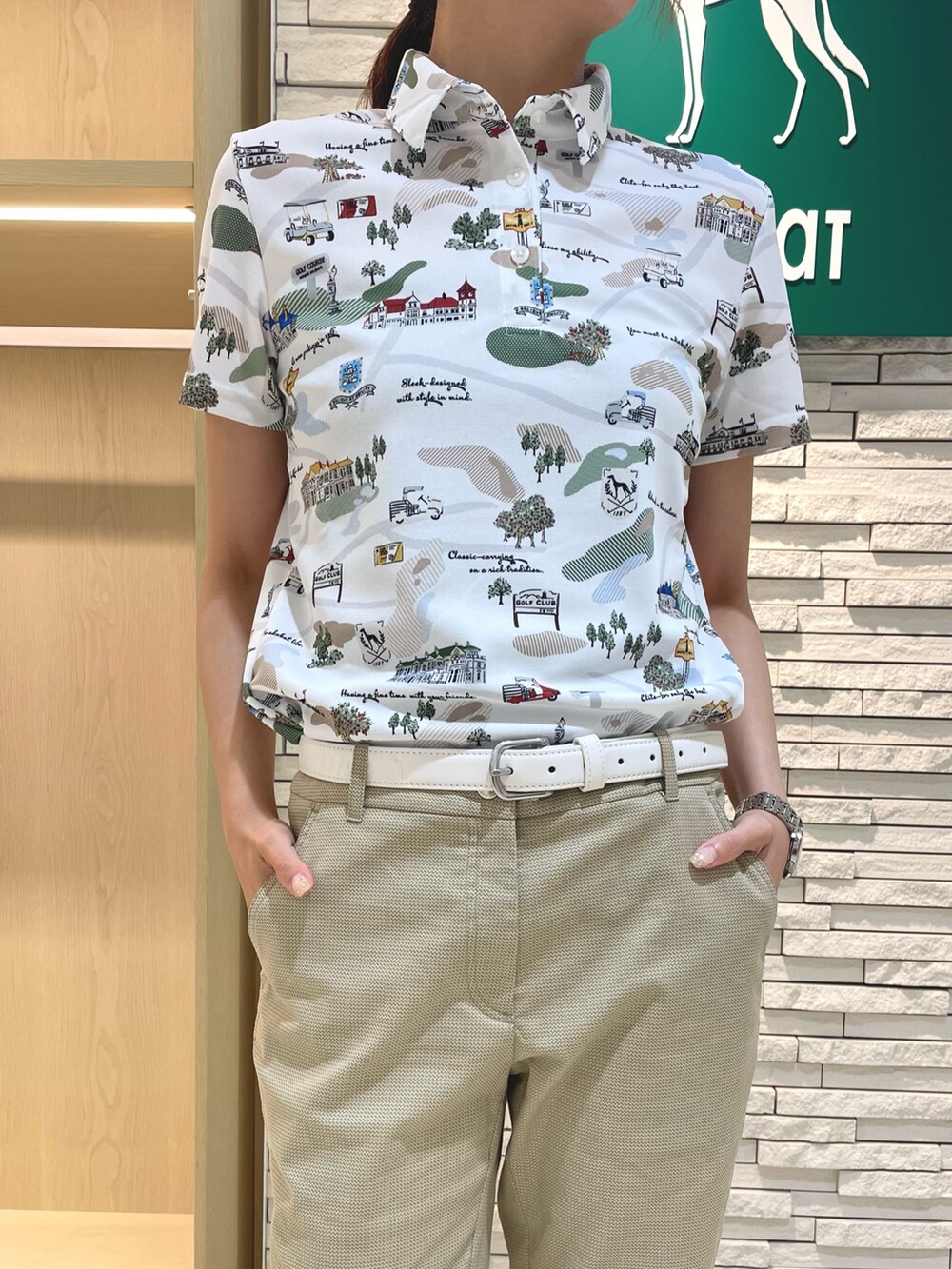 グリーン系のポロシャツ、ベージュ系のその他パンツ、ブラック系のハンドバッグを着用したレディースの秋コーディネートの4枚目の写真