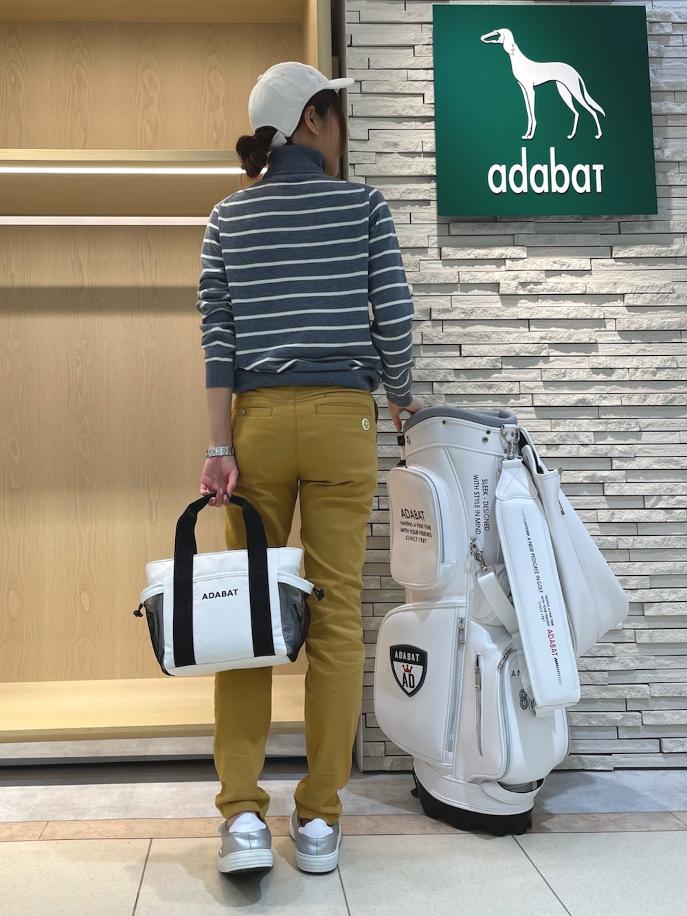 グレー系のニット/セーター、イエロー系のその他パンツ、ホワイト系のトートバッグを着用したレディースの秋コーディネートの3枚目の写真