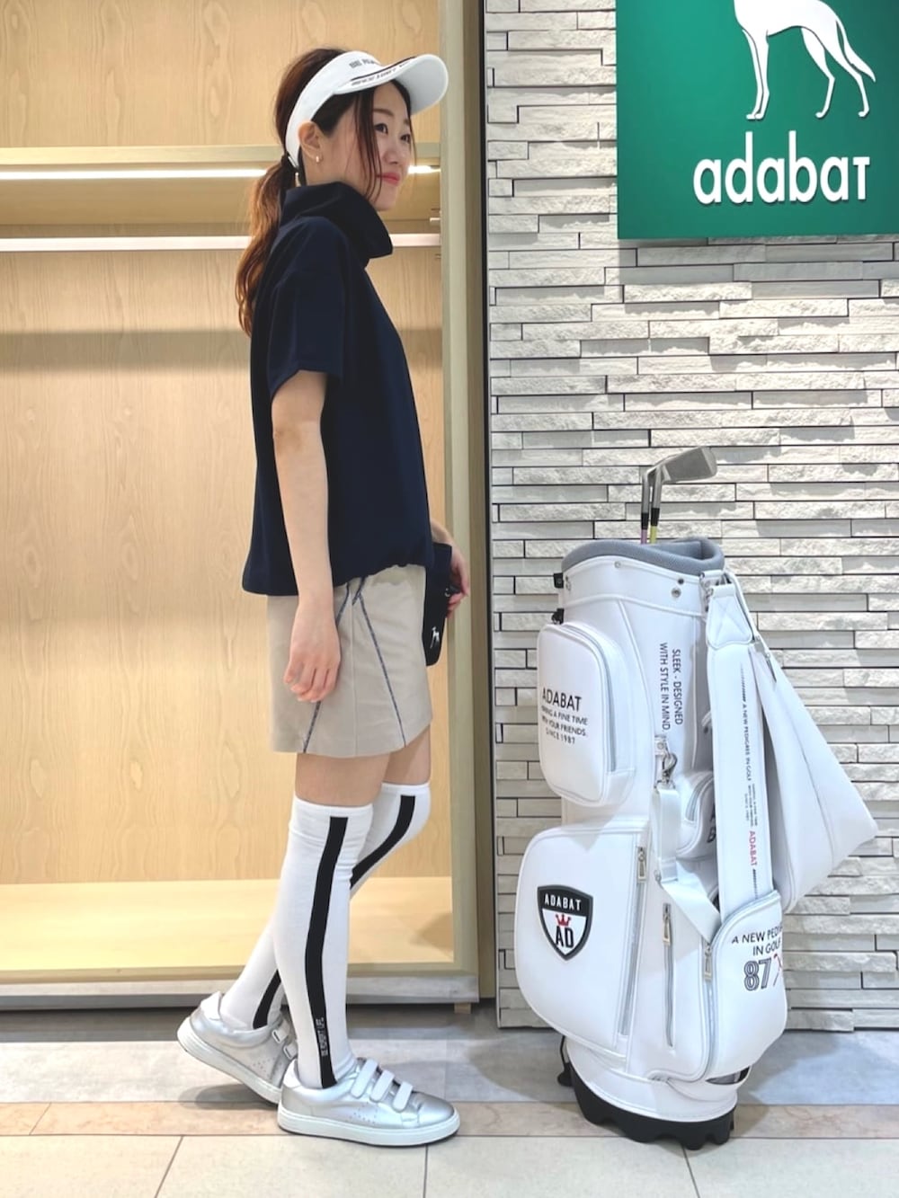 ベージュ系のスカート、ホワイト系のTシャツ/カットソー、ブルー系のトートバッグを着用したレディースの夏コーディネートの2枚目の写真