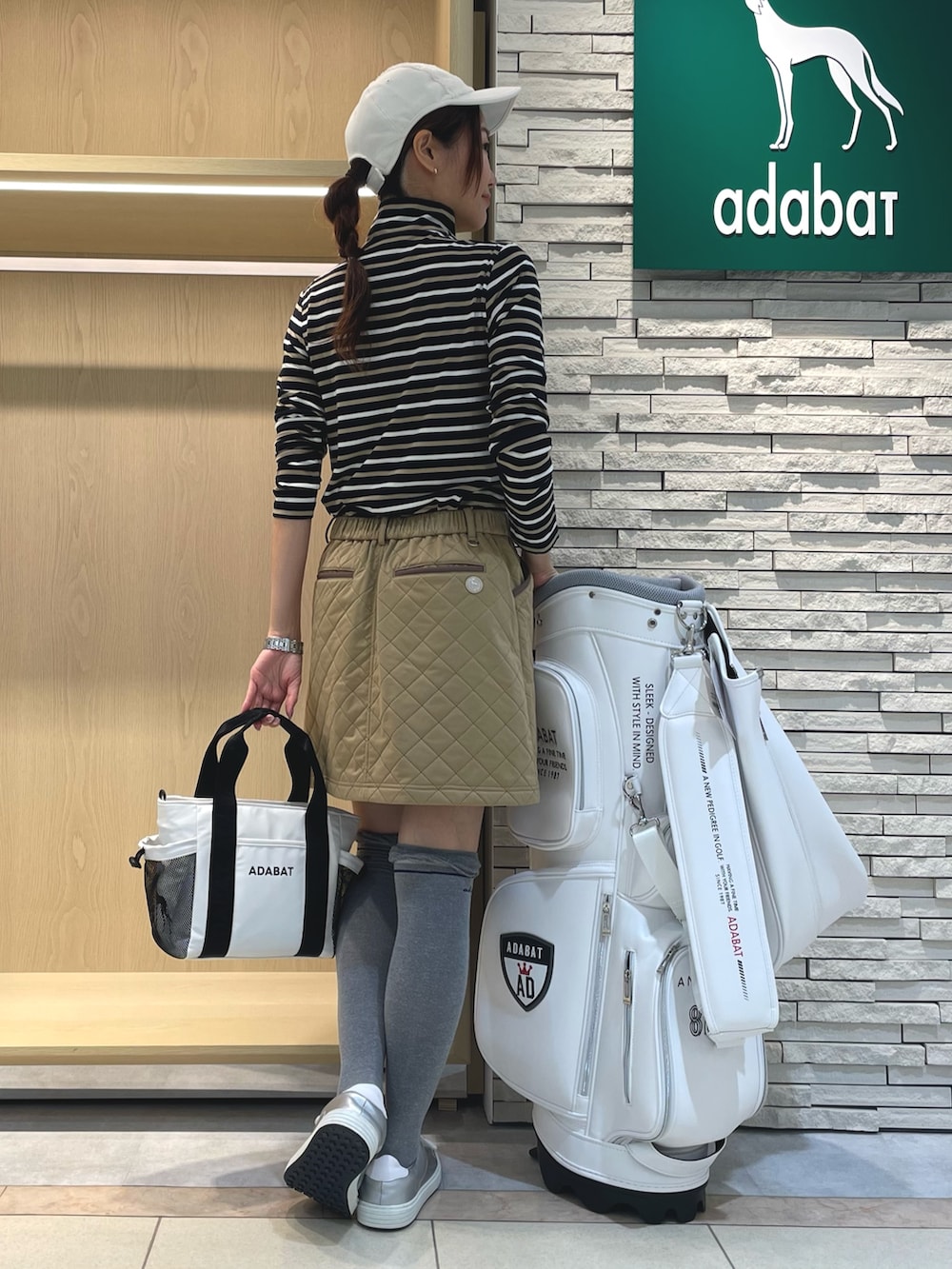 ブルー系のTシャツ/カットソー、イエロー系のスカート、ホワイト系のキャップを着用したレディースの冬コーディネートの3枚目の写真