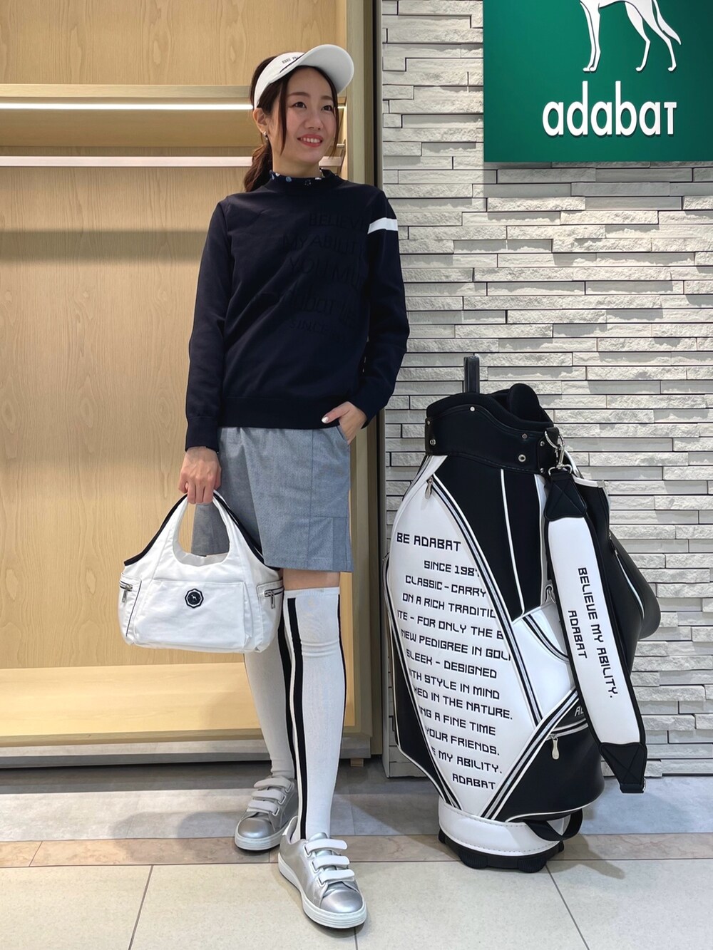 ブルー系のスカート、ベージュ系のブルゾン、ブルー系のニット/セーターを着用したレディースの春コーディネートの2枚目の写真