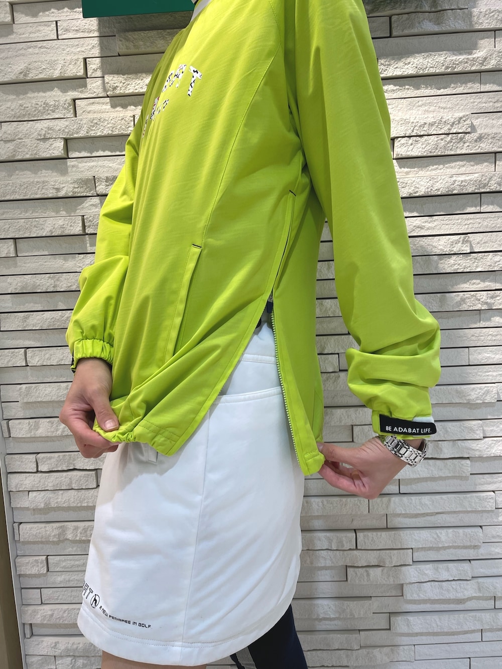 グリーン系のスカート、イエロー系のブルゾン、ホワイト系のTシャツ/カットソーを着用したレディースの冬コーディネートの4枚目の写真