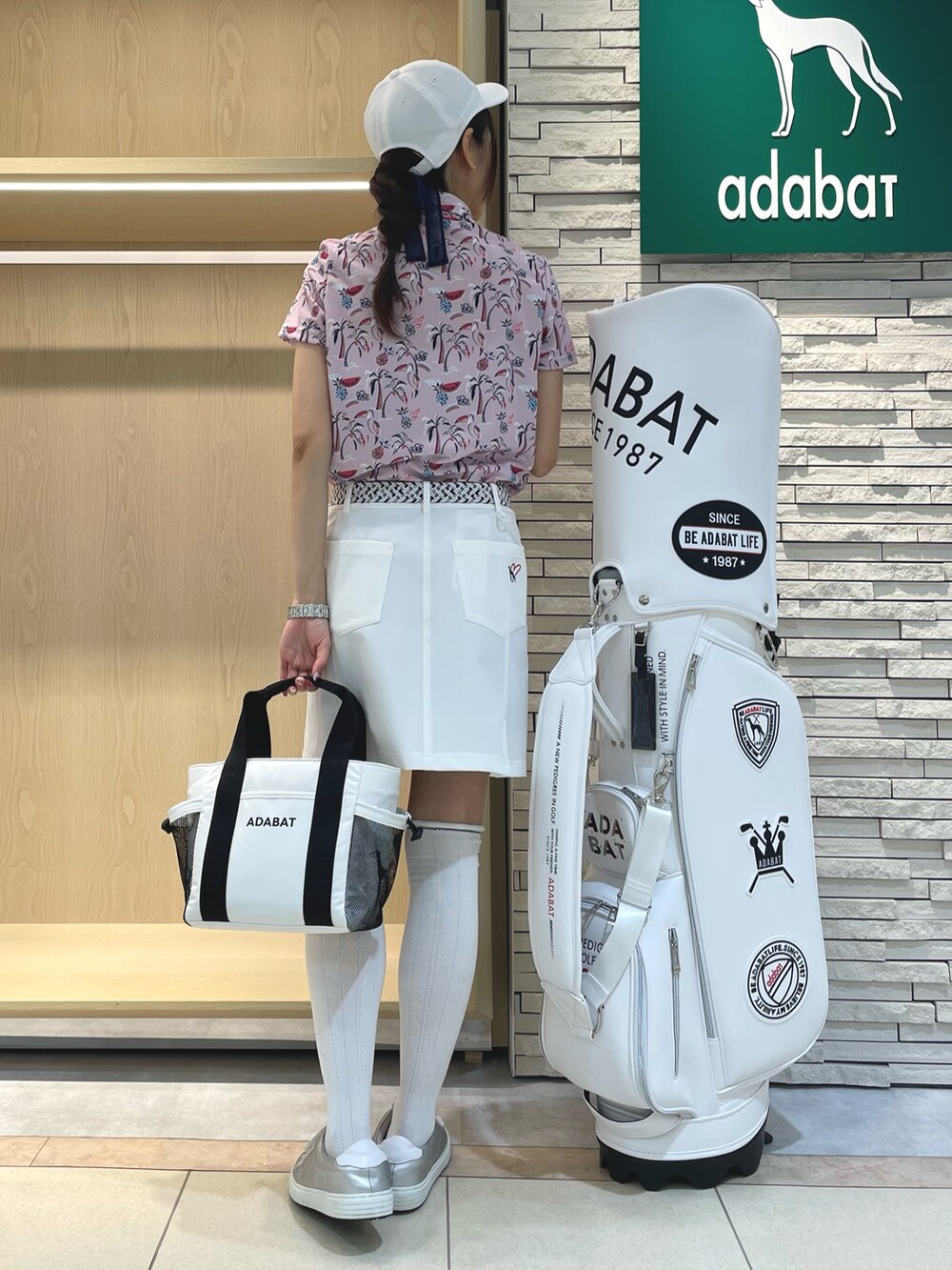 ピンク系のシャツ/ブラウス、ホワイト系のスカート、ホワイト系のトートバッグを着用したレディースの夏コーディネートの2枚目の写真