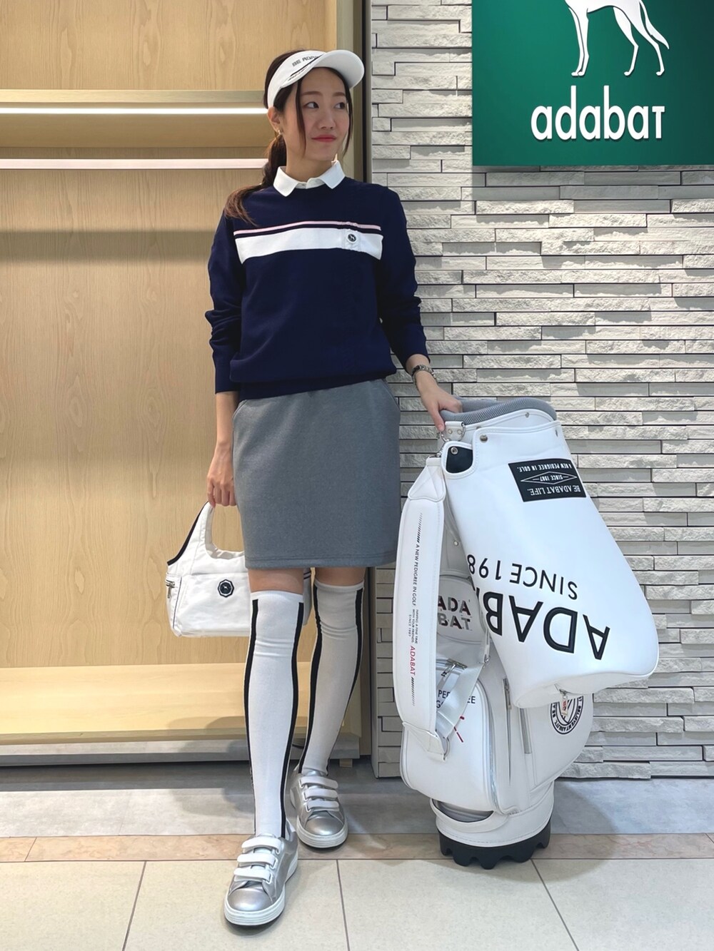 ブルー系のブルゾン、ブルー系のニット/セーター、ホワイト系のトートバッグを着用したレディースの春コーディネートの2枚目の写真