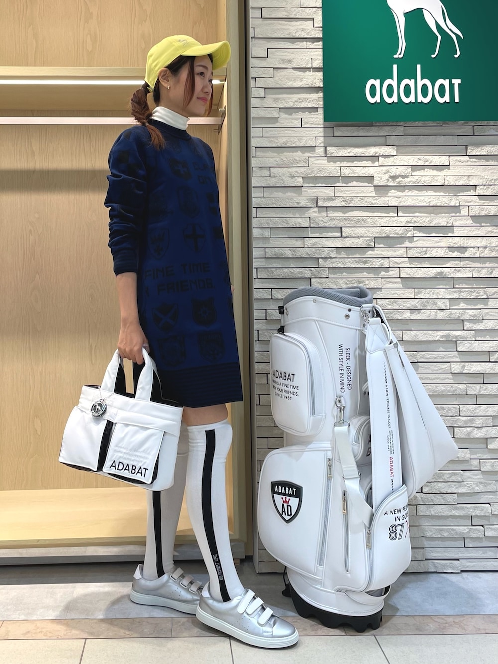 ブルー系のワンピース、ホワイト系のハンドバッグ、イエロー系のキャップを着用したレディースの秋コーディネートの3枚目の写真