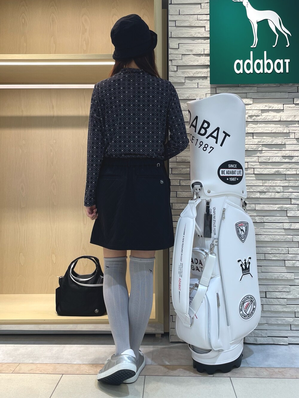 ブラック系のスカート、ブラック系のTシャツ/カットソー、ブラック系のハンドバッグを着用したレディースの秋コーディネートの3枚目の写真