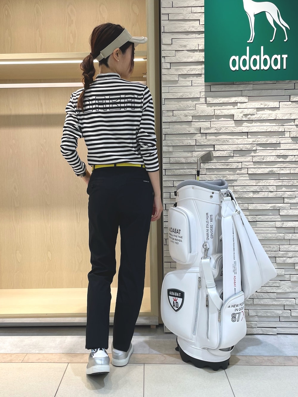 ブラック系のその他パンツ、ホワイト系のTシャツ/カットソー、ベージュ系のサンバイザーを着用したレディースの夏コーディネートの3枚目の写真