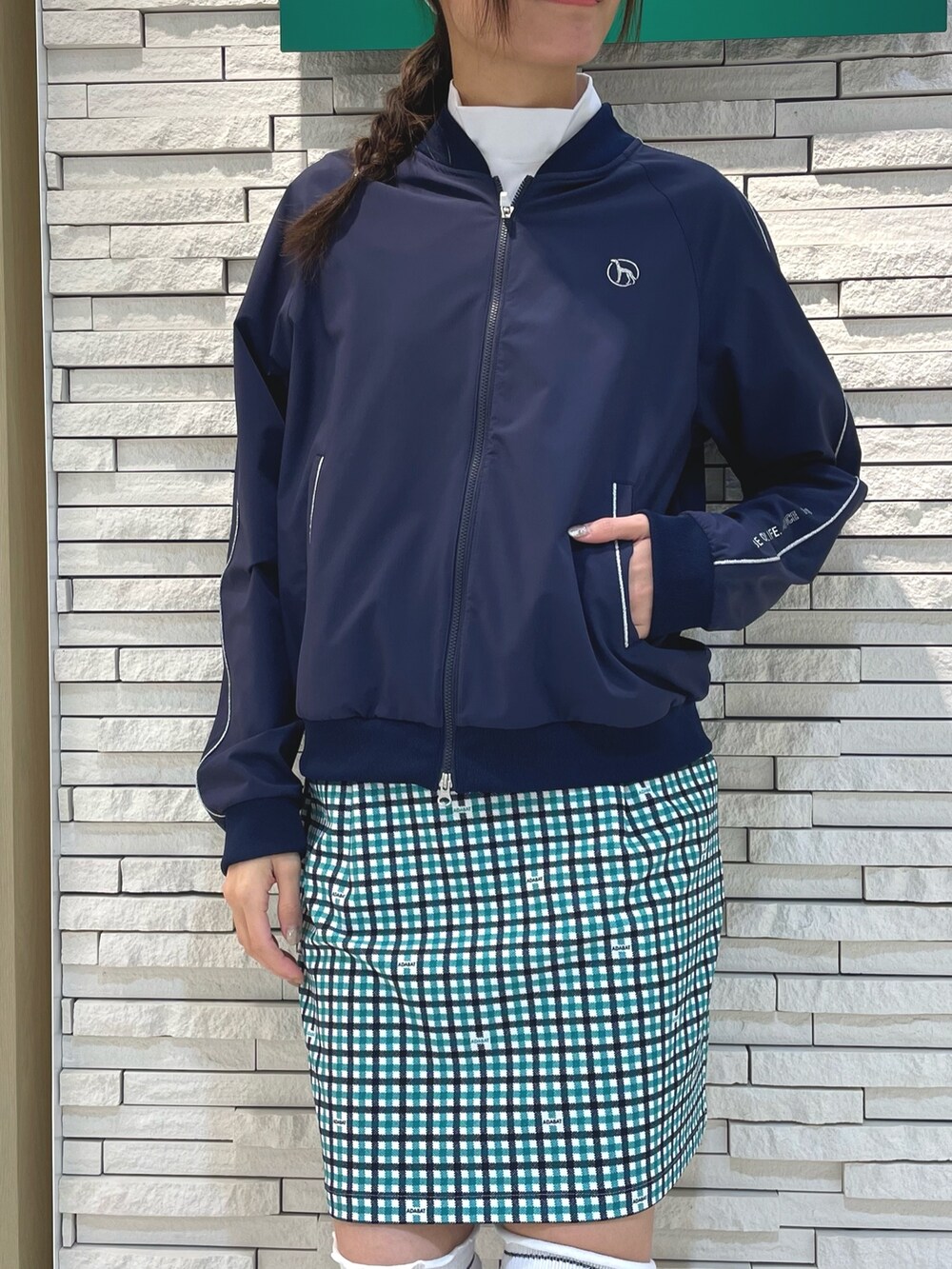 ホワイト系のスカート、ブルー系のブルゾン、ホワイト系のTシャツ/カットソーを着用したレディースの春コーディネートの3枚目の写真