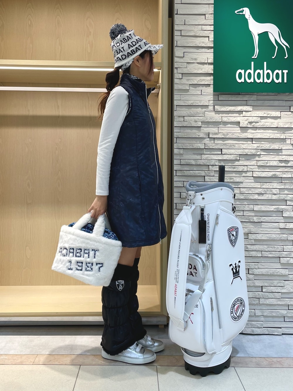 ブルー系のワンピース、ホワイト系のハンドバッグ、ホワイト系のTシャツ/カットソーを着用したレディースの冬コーディネートの2枚目の写真