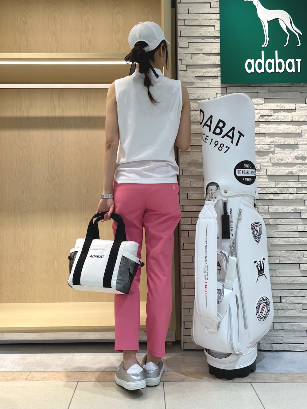 ホワイト系のポロシャツ、ピンク系のその他パンツ、ホワイト系のトートバッグを着用したレディースの夏コーディネートの2枚目の写真