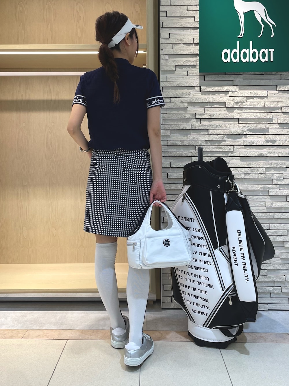 ブルー系のスカート、ブルー系のニット/セーター、ホワイト系のトートバッグを着用したレディースの春コーディネートの2枚目の写真