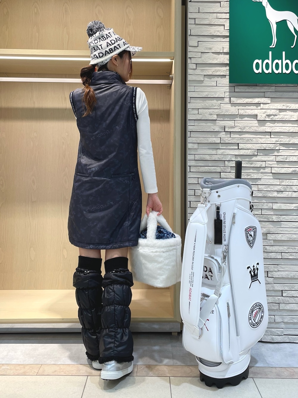 ブルー系のワンピース、ホワイト系のハンドバッグ、ホワイト系のTシャツ/カットソーを着用したレディースの冬コーディネートの3枚目の写真