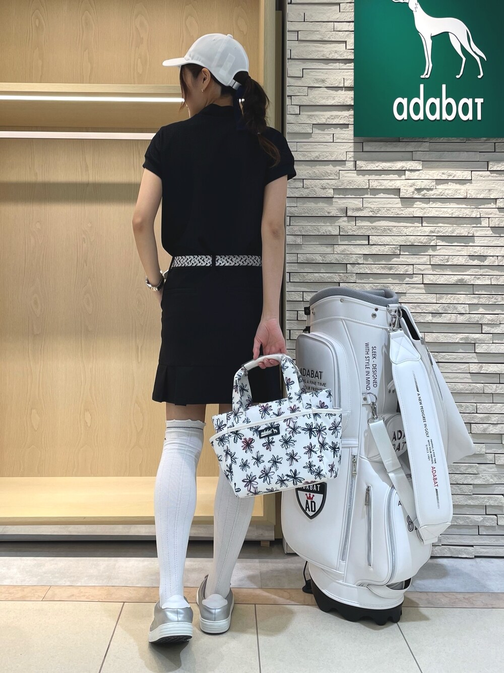 ブラック系のスカート、ブルー系のTシャツ/カットソー、ホワイト系のハンドバッグを着用したレディースの春コーディネートの3枚目の写真