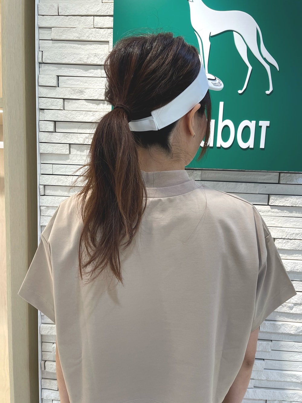 ベージュ系のワンピース、ブルー系のトートバッグ、ホワイト系のサンバイザーを着用したレディースの夏コーディネートの4枚目の写真