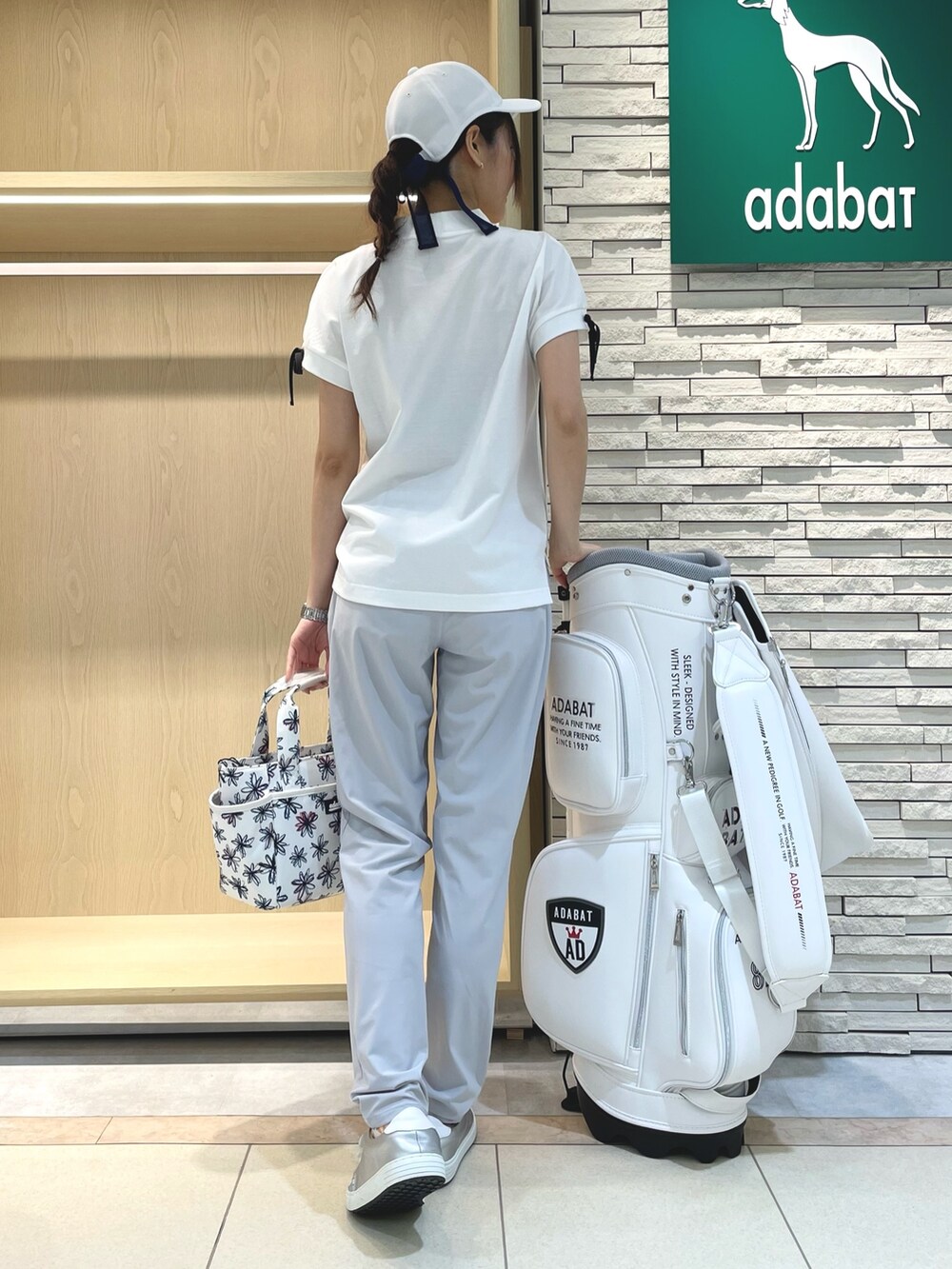 ホワイト系のTシャツ/カットソー、グレー系のその他パンツ、ホワイト系のハンドバッグを着用したレディースの春コーディネートの2枚目の写真